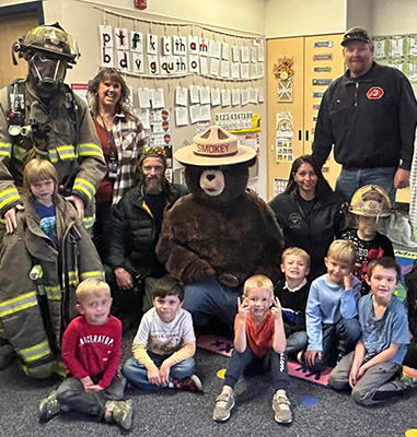 Students, teachers, and fire fighters with Smokey the Bear