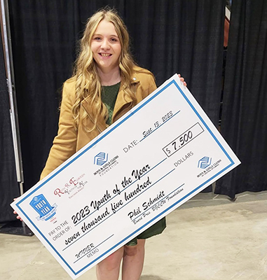 Happy young lady holding up a large check