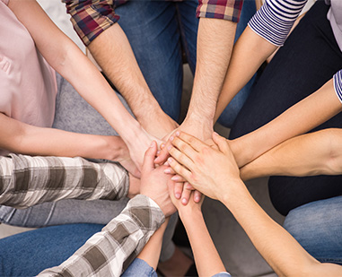 Students and staff putting hands together