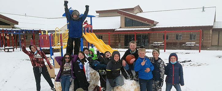 Students enjoying recess on the school playground with snow on the ground