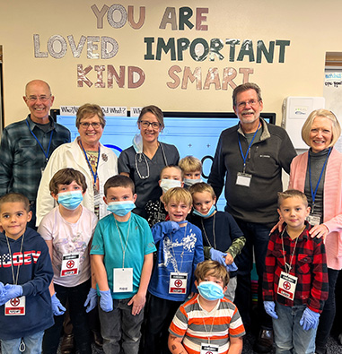 Teachers and students in front of You are Loved, Important, Kind, Smart sign