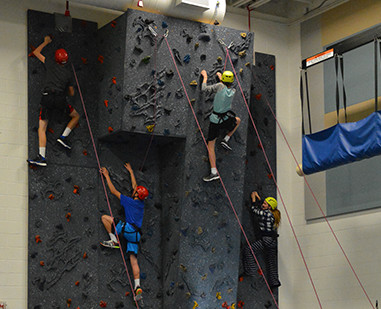 Students on a rock climbing wall.