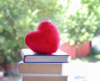 stack of books with a heart on top