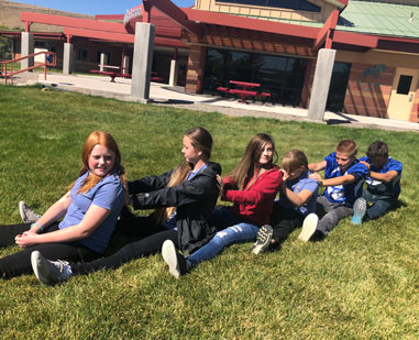 Students sitting together to form a chain